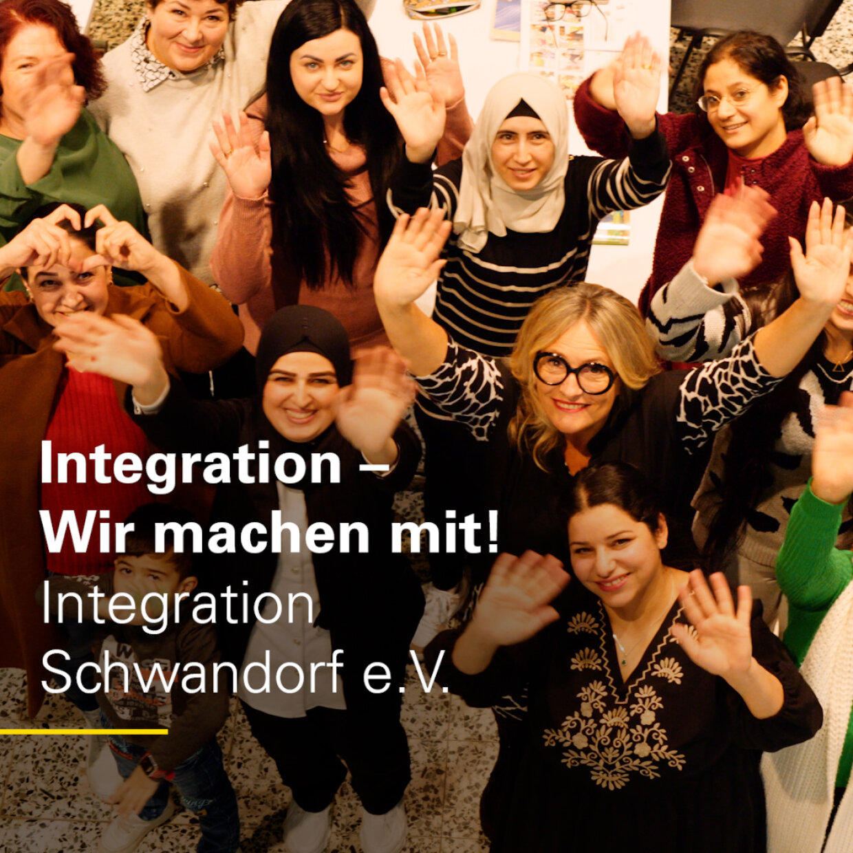 Auf dem Bild sind mehrere Ehrenamtliche und Teilnehmerinnen der Kurse des Vereins Integration Schwandorf e. V. zu sehen, die in die Kamera winken.