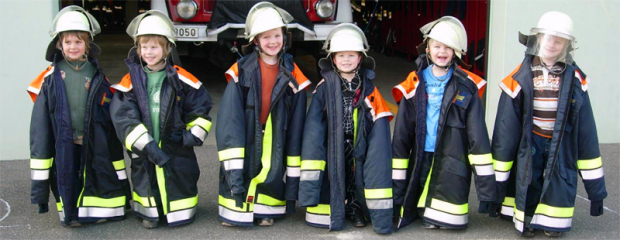 Kinder in (zu großen) Feuerwehruniformen