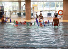 Kinder mit Schwimmnudel im Schwimmbecken