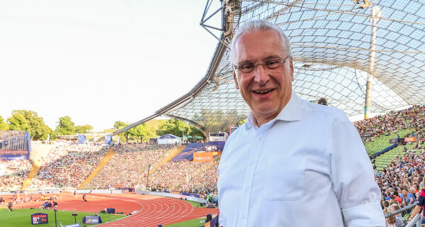 Sportminister Joachim Herrmann auf Tribüne im vollen Olympiastadtion