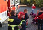 Feuerwehrmann befestigt Rucksackcover an Kinderschulranzen