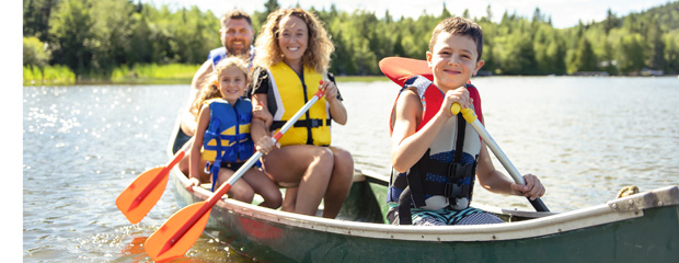 Symbolbild: Erwachsene mit Kindern in einem Ruderboot.